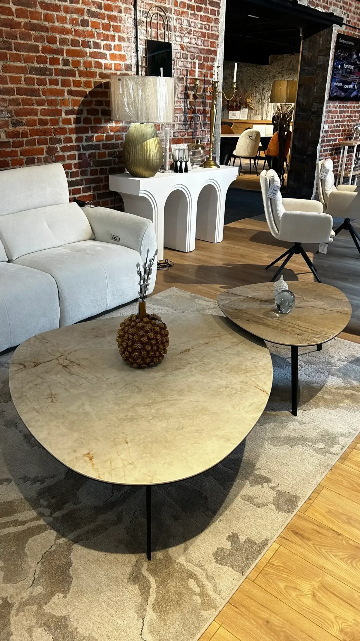 Intérieur du magasin MMHome : canapés et tables basses sous les murs en briques de l'ancienne brasserie-malterie de Préseau
