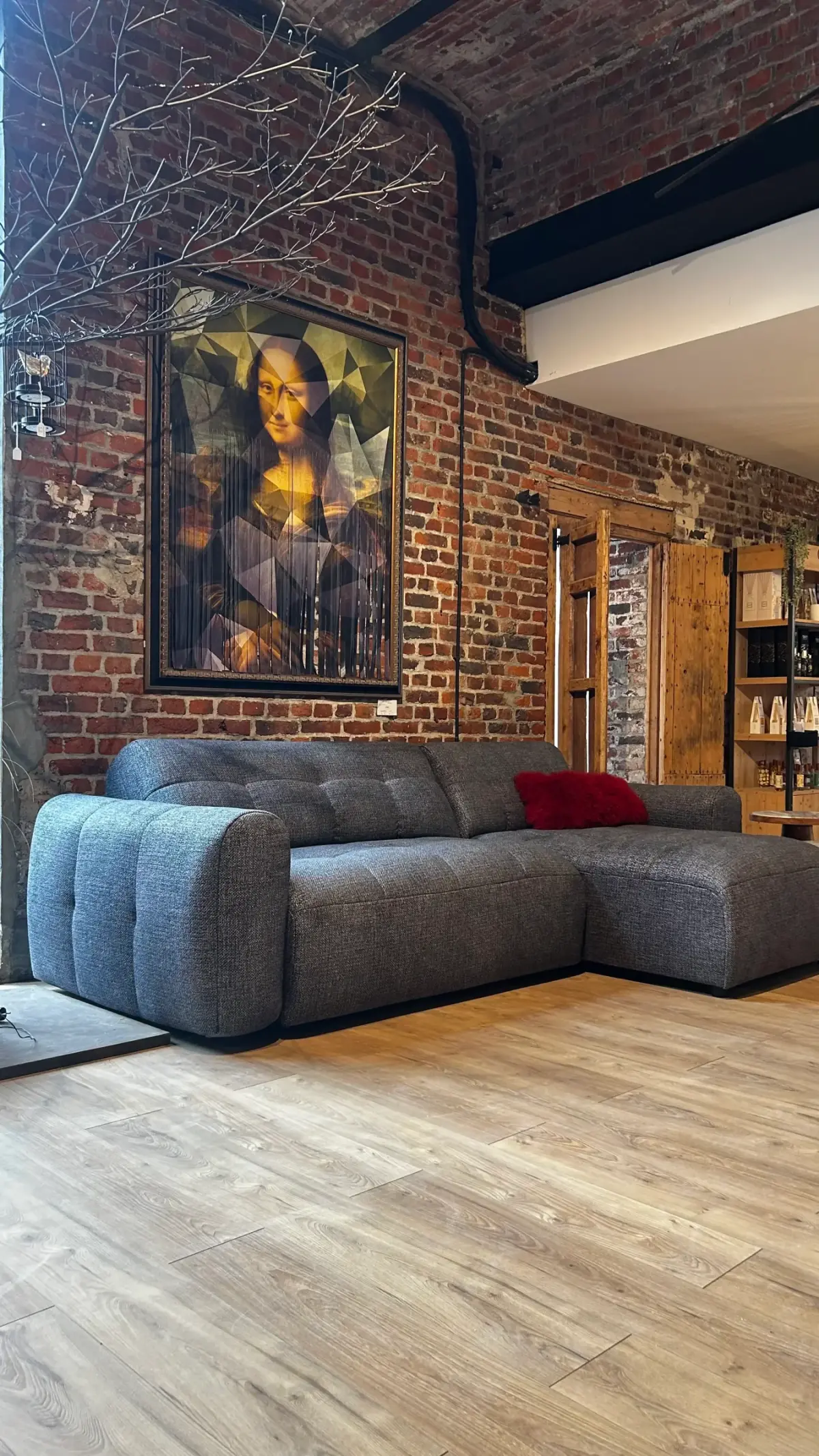 Canapé d'angle exposé devant un mur en briques dans le magasin MMHome de Préseau